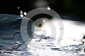 Water Droplets Falling Into A Pond Creating Ripples On Water Lily