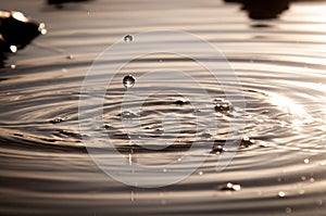 Water Droplets Falling Into A Pond At Sunset