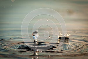 Water Droplets Falling Into A Pond At Sunset