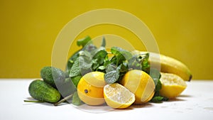 Water droplets falling in slow motion on healthful fruits and vegetables at yellow background. Drops on yellow citrus