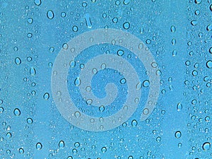 Water droplets on glass, blue sky