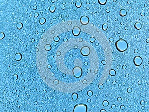 Water droplets on glass, blue sky