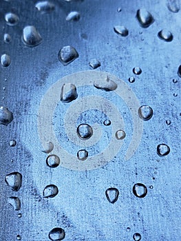 Water droplets on a metal plate with holes, close-up. Macro photo