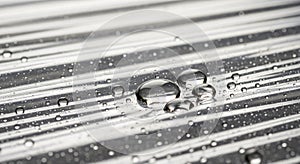 Water droplets rest on a metallic,