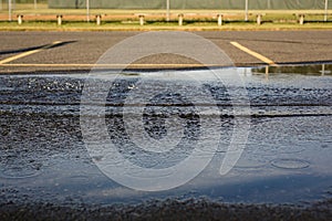 Water Droplets and Ripples in Puddle on Asphalt, United States