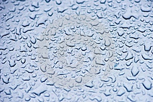 Water droplets on the turquoise surface of the metal