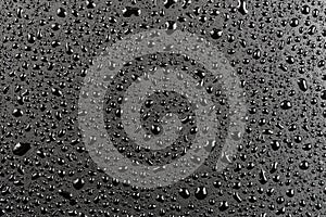 Water drops on abstract flat black hydrophobic surface macro background