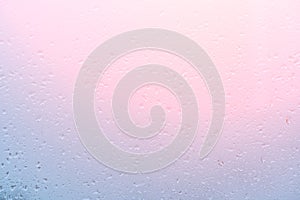 Water Drops Background. Rain drops on window on sunset, pink blue background. drop of water on glass in a pink glow. pink