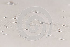 Water drops on beige waterproof fabric. Horizontal image.