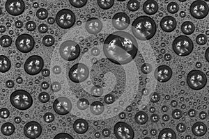 Water drops on black background texture. Dark backdrop glass covered with drops of water. gray bubbles in water