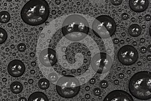 Water drops on black background texture. Dark backdrop glass covered with drops of water. gray bubbles in water