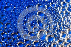 Water drops on a blue glass surface