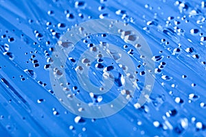 Water drops on a cellophane film, dark blue toning photo