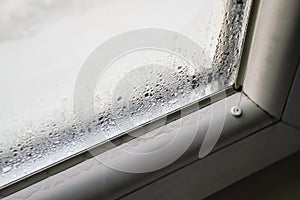 Water drops condensed at cold window during winter season, closeup detail