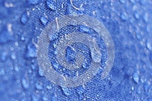 Water drops on the fabric. Rain Water droplets on blue fiber waterproof fabric. Water drops pattern over a waterproof