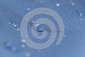 Water drops on the fabric. Rain Water droplets on blue fiber waterproof fabric. Water drops pattern over a waterproof