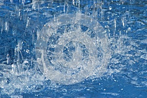 Water drops fall on the surface and form circles and funnels.