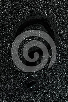 Water drops on flat black rubber surface with the inscription - question mark