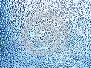 Water drops on the glass in a cool blue tones. in the rainy season. For textures and backgrounds.