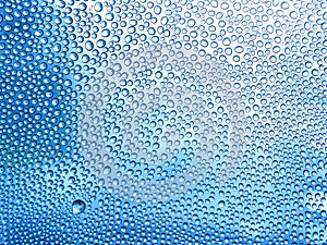 Water drops on the glass in a cool blue tones. in the rainy season. For textures and backgrounds.