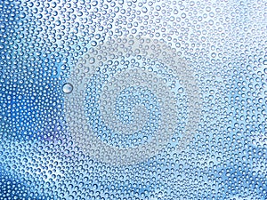 Water drops on the glass in a cool blue tones. in the rainy season. For textures and backgrounds.