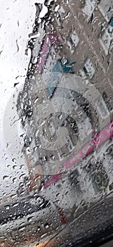 water drops on glass side mirror of car closeup rainy day view from window