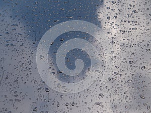 Water drops on the hood of a metallic black car