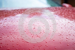Water drops on red car, shallow depth of field, selective focus photo