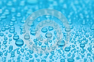 Water drops on light blue background, closeup