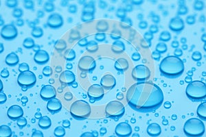 Water drops on light blue background, closeup