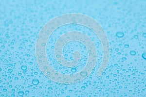 Water drops on light blue background, closeup