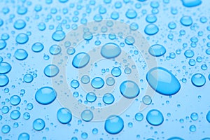 Water drops on light blue background, closeup