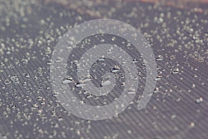 Water drops on a light warm gray background.