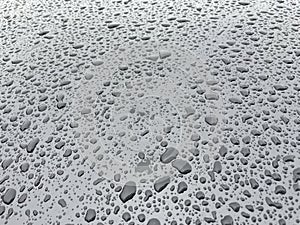 Water drops in metallic surface. Water droplet on the car hood. After rain texture.