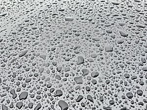 Water drops in metallic surface. Water droplet on the car hood. After rain texture.