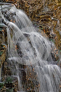 Water Drops Over The Crest Of A Rocky Waterfall