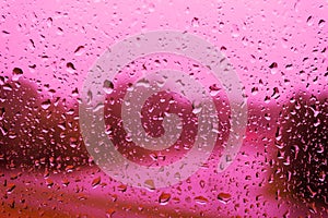 Water drops on pink glass