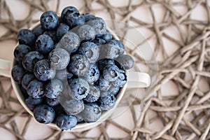 Water drops on ripe blueberries in small white dish