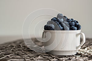 Water drops on ripe blueberries in small white dish