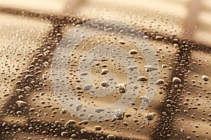 Water drops in a shiny metallic surface with table re