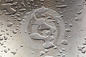 Water drops on silver metal table in harmonic form