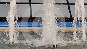 Water drops splashing on water surface. Close up of water fountain. Powerfull water stream. Water background. Shinning