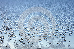 Water drops on the wet window glass. Abstract background. Blue color