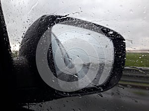 Water drops on the window affect the visibility in the rear mirror.