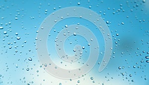 Water drops on the window, blue sky and clouds in the blurry background