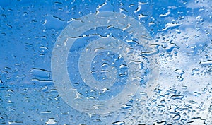 Water drops window glass blue sky