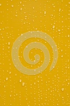 Water drops on yellow metal background