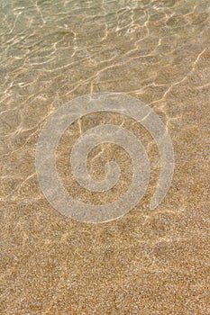 Water erodes the sand on the beach