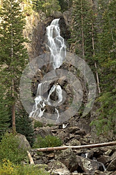 Water fall cascading down a mountain in late afternoon sunlight