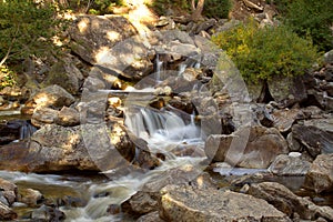 Water fall cascading down a mountain in late afternoon sunlight